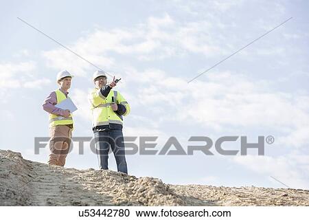 Low angle view of supervisors discussing at construction site against sky View Large Photo Image Stock Image - Low angle view of supervisors discussing at construction site against sky. Fotosearch