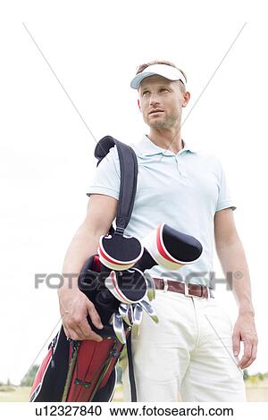 Low angle view of thoughtful mid-adult man carrying golf club bag against clear sky View Large Photo Image Stock Image - Low angle view of thoughtful mid-adult man carrying golf club bag against clear sky. Fotosearch