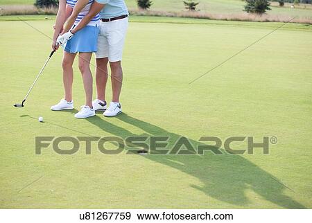 Stock Photo - Low section of couple playing golf. Fotosearch