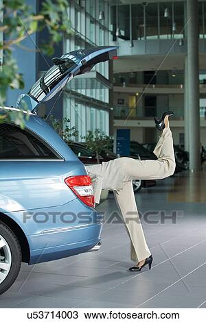 Stock Image - Low section of female customer examining car interior. Fotosearch