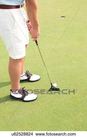 Picture - Low section of man playing golf at course. Fotosearch