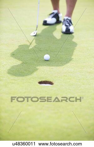 Stock Image - Low section of man playing golf. Fotosearch