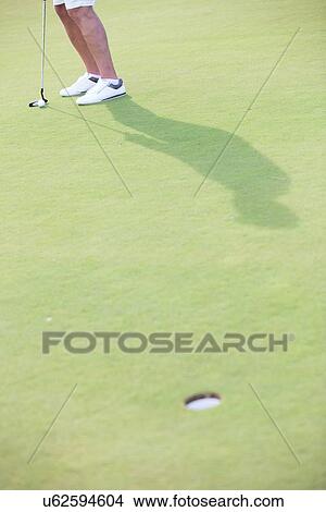 Picture - Low section of middle-aged man playing golf at course. Fotosearch