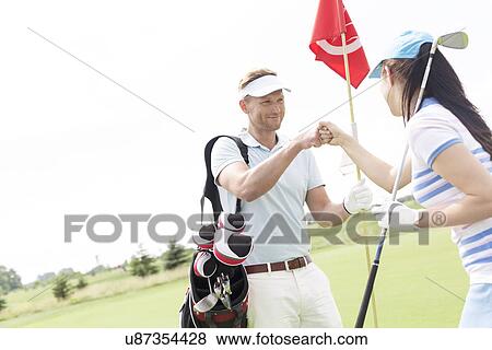 Male and female friends giving high-five at golf course View Large Photo Image Stock Photo - Male and female friends giving high-five at golf course. Fotosearch