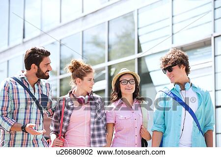 Stock Image - Male and female friends talking outside building. Fotosearch