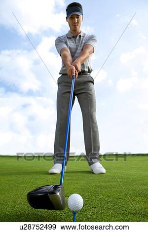 Man about to strike golf ball, low angle view View Large Photo Image Stock Photo - Man about to strike golf ball, low angle view. Fotosearch