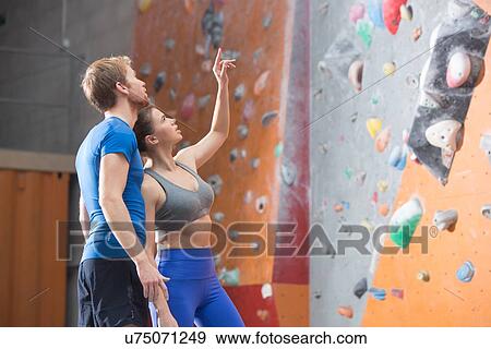 Man and woman discussing by climbing wall in crossfit gym View Large Photo Image Stock Photo - Man and woman discussing by climbing wall in crossfit gym. Fotosearch
