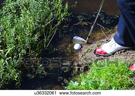 Man chipping ball from water hazard View Large Photo Image Stock Image - Man chipping ball from water hazard. Fotosearch