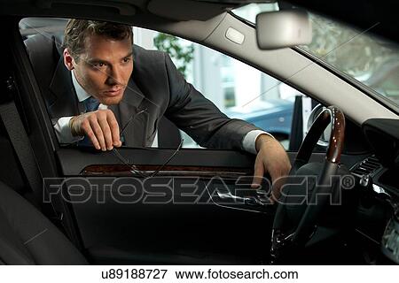 Man looking at new car in showroom View Large Photo Image Stock Photo - Man looking at new car in showroom. Fotosearch
