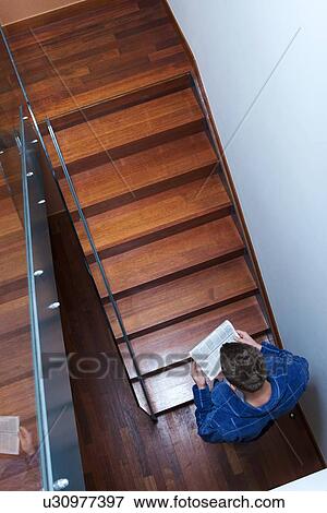 Man reading newspaper on stairs View Large Photo Image Stock Photo - Man reading newspaper on stairs. Fotosearch