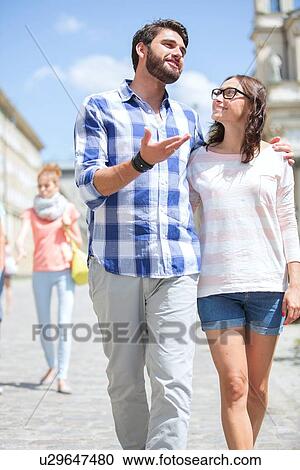 Man talking to woman while walking on street View Large Photo Image Stock Image - Man talking to woman while walking on street. Fotosearch