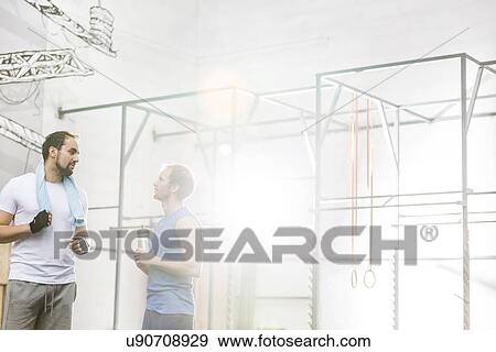 Stock Photo - Men conversing in crossfit gym. Fotosearch