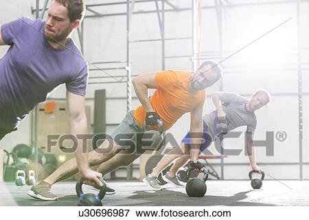 Men exercising with kettlebells in crossfit gym View Large Photo Image Stock Photo - Men exercising with kettlebells in crossfit gym. Fotosearch