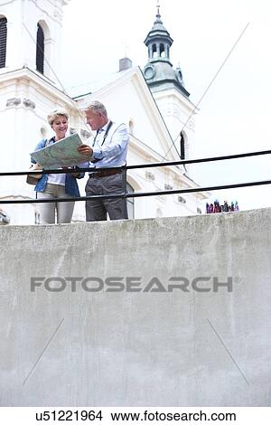 Middle-aged couple reading map by railing outside church View Large Photo Image Picture - Middle-aged couple reading map by railing outside church. Fotosearch