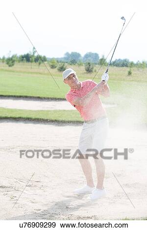 Stock Photo - Middle-aged man playing at golf course. Fotosearch