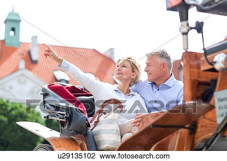 Middle-aged woman showing something to man while sitting in horse cart View Large Photo Image Stock Image - Middle-aged woman showing something to man while sitting in horse cart. Fotosearch