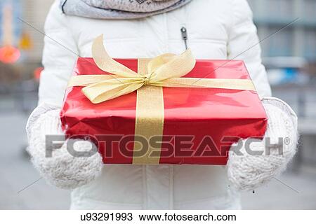 Midsection of woman holding gift box winter View Large Photo Image Stock Image - Midsection of woman holding gift box winter. Fotosearch