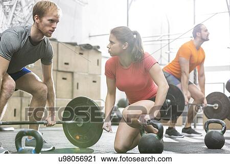 Stock Image - People weightlifting in crossfit gym. Fotosearch
