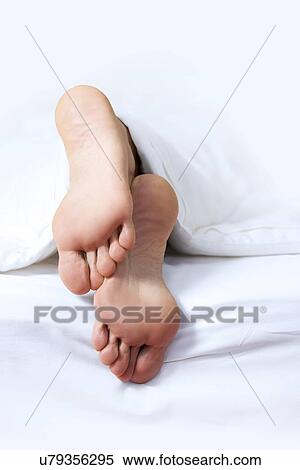 Stock Photography - Person's foot in bed. Fotosearch