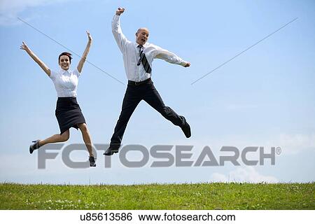 Stock Photograph - Portrait of business couple enjoying in park. Fotosearch
