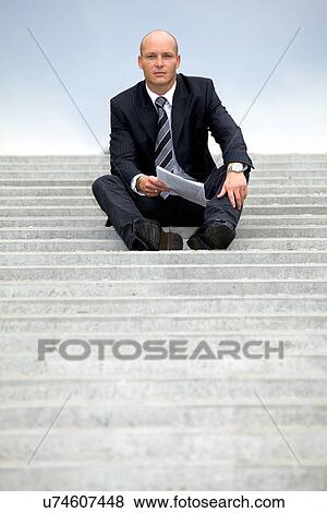Portrait of businessman holding document on steps View Large Photo Image Stock Photo - Portrait of businessman holding document on steps. Fotosearch