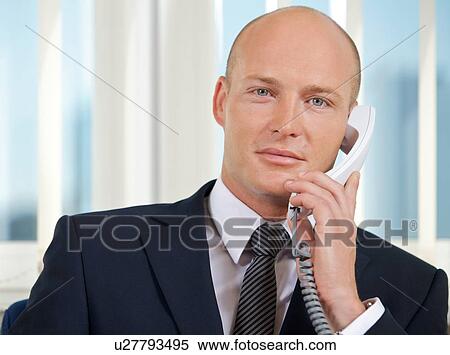 Portrait of businessman talking on telephone at office View Large Photo Image Stock Photography - Portrait of businessman talking on telephone at office. Fotosearch