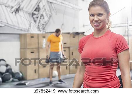 Portrait of happy woman standing in crossfit gym View Large Photo Image Stock Photo - Portrait of happy woman standing in crossfit gym. Fotosearch