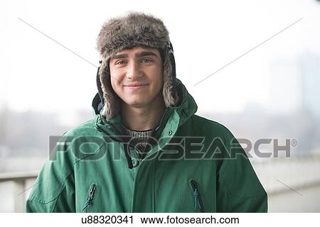 Stock Image - Portrait of man in winter wear smiling outdoors. Fotosearch