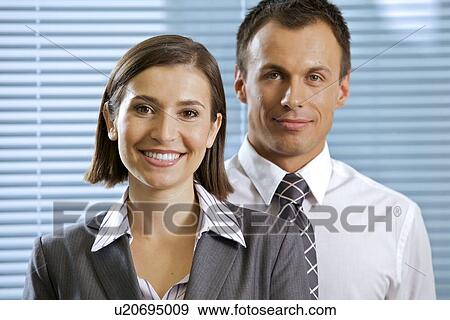 Stock Photo - Portrait of smiling businessman and woman in office. Fotosearch