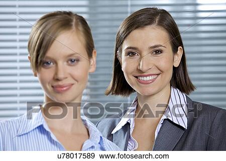 Stock Photo - Portrait of smiling businesswomen in office. Fotosearch