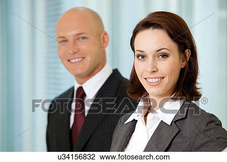 Stock Image - Portrait of young caucasian businessman and businesswoman in office. Fotosearch