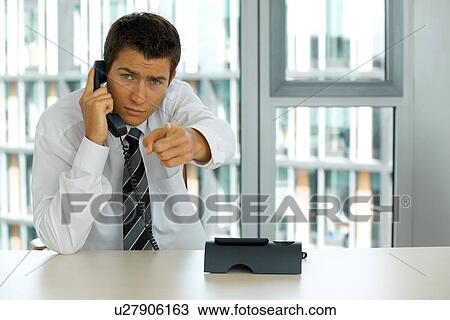Stock Image - portrait of young confident caucasian businessman talking on phone. Fotosearch