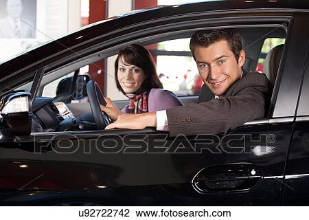 Portrait of young couple sitting in a new car at showroom View Large Photo Image Stock Image - Portrait of young couple sitting in a new car at showroom. Fotosearch
