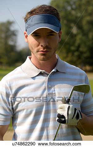 Portrait of young man holding golf stick View Large Photo Image Stock Image - Portrait of young man holding golf stick. Fotosearch