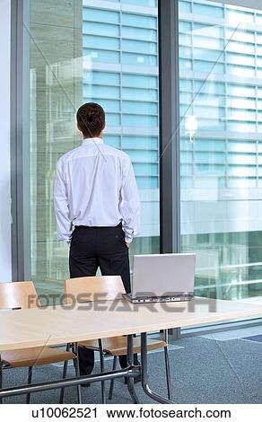Rear view of businessman standing in office with hands in pocket View Large Photo Image Stock Image - Rear view of businessman standing in office with hands in pocket. Fotosearch