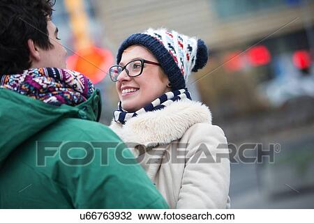 Stock Image - Romantic couple looking at each other in city during winter. Fotosearch