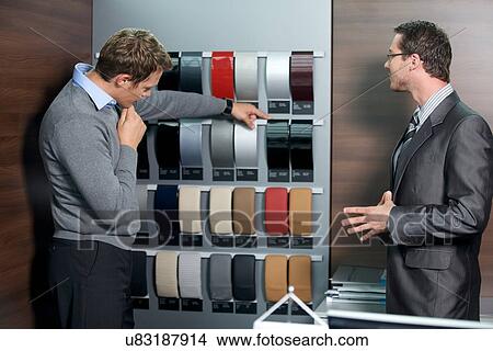 Picture - Salesperson showing color swatch to customer. Fotosearch
