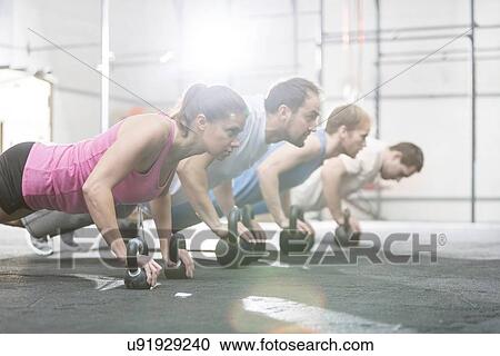 Side view of determined people doing pushups with kettlebells at crossfit gym View Large Photo Image Stock Image - Side view of determined people doing pushups with kettlebells at crossfit gym. Fotosearch