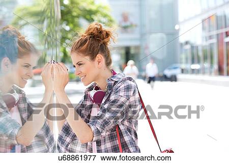 Side view of happy woman window shopping in city View Large Photo Image Stock Photo - Side view of happy woman window shopping in city. Fotosearch