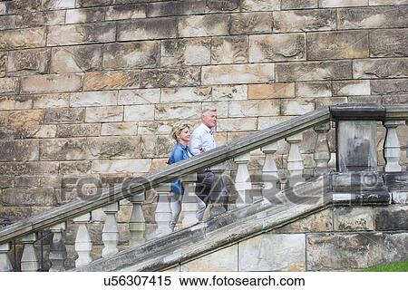 Side view of middle-aged couple climbing steps outside old building View Large Photo Image Stock Photography - Side view of middle-aged couple climbing steps outside old building. Fotosearch