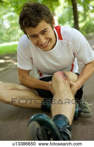 Skater injured and clutching leg View Large Photo Image Stock Image - Skater injured and clutching leg. Fotosearch