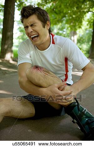 Skater injured and clutching leg View Large Photo Image Stock Image - Skater injured and clutching leg. Fotosearch