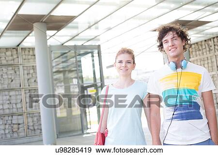 Smiling couple looking away while standing in city View Large Photo Image Stock Photo - Smiling couple looking away while standing in city. Fotosearch