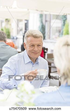 Smiling middle-aged man having coffee with woman at sidewalk cafe View Large Photo Image Stock Photo - Smiling middle-aged man having coffee with woman at sidewalk cafe. Fotosearch