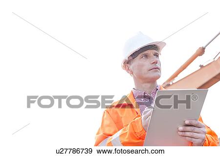 Supervisor looking away while holding clipboard against clear sky View Large Photo Image Stock Photo - Supervisor looking away while holding clipboard against clear sky. Fotosearch