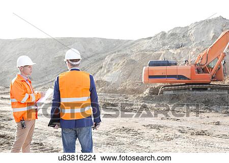 Picture - Supervisors standing at construction site against clear sky. Fotosearch