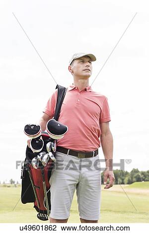 Thoughtful middle-aged man looking away while carrying golf bag against clear sky View Large Photo Image Stock Image - Thoughtful middle-aged man looking away while carrying golf bag against clear sky. Fotosearch