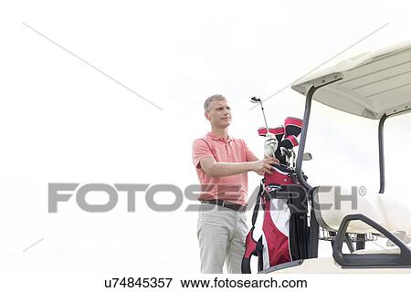 Thoughtful middle-aged man standing by cart against clear sky View Large Photo Image Stock Photo - Thoughtful middle-aged man standing by cart against clear sky. Fotosearch