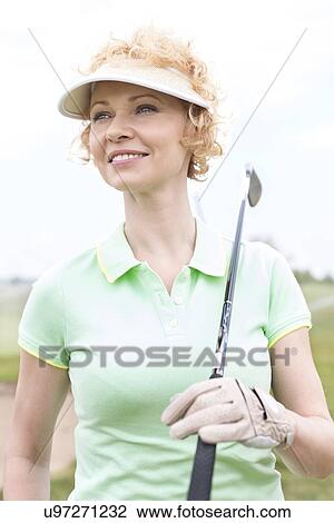 Thoughtful middle-aged woman looking away while holding golf club View Large Photo Image Stock Image - Thoughtful middle-aged woman looking away while holding golf club. Fotosearch