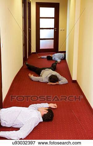 Stock Photo - Three businessman lying down in office. Fotosearch